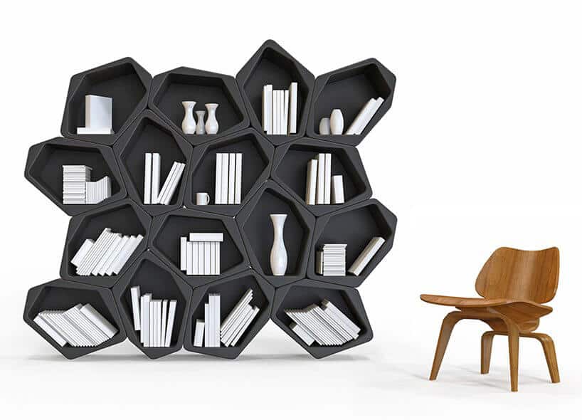 nowoczesny regał na książki czarny z nieregularnymi półkami obok drewnianego krzesła