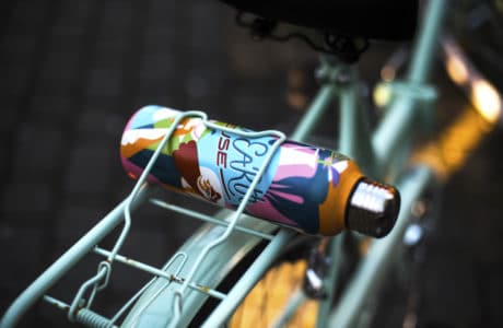 kolorowa butelka umieszczona w bagażniku roweru w kolorze miętowym