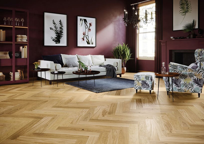 elegancki salon z bordowymi ścianami i drenwnianym parkietem z białą sofą bordową szafką