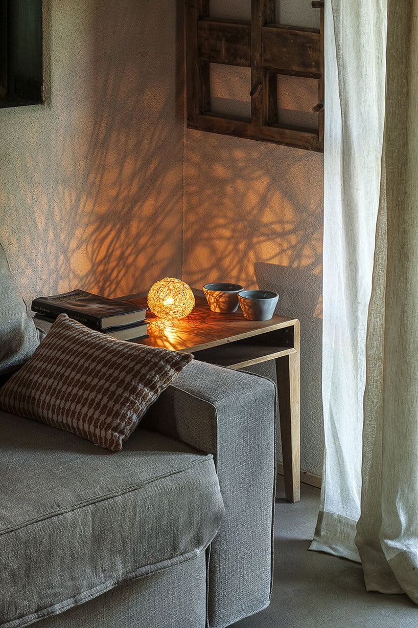nowoczesne lampka Sweet Light od Catellani&Smith na drewnianym stoliku obok szarej sofy
