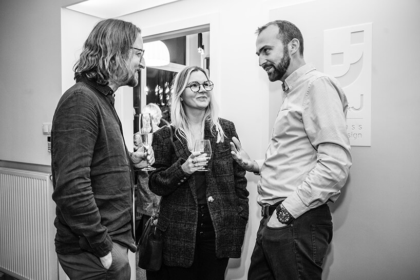 trzy osoby podczas rozmów na otwarciu Chłodna 11 concept showroomu J&J glass & design