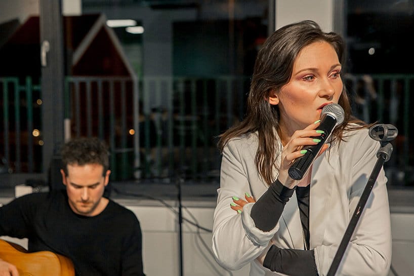 kobieta śpiewająca obok gitarzysty