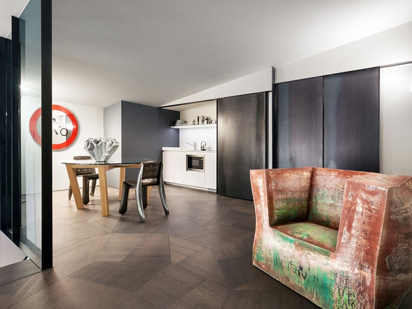 elegancki penthouse od Zaha Hadid nowoczesne wnętrze jadalni z kuchnią ze stołem ze szklanym blatem i wyjątkowymi krzesłami