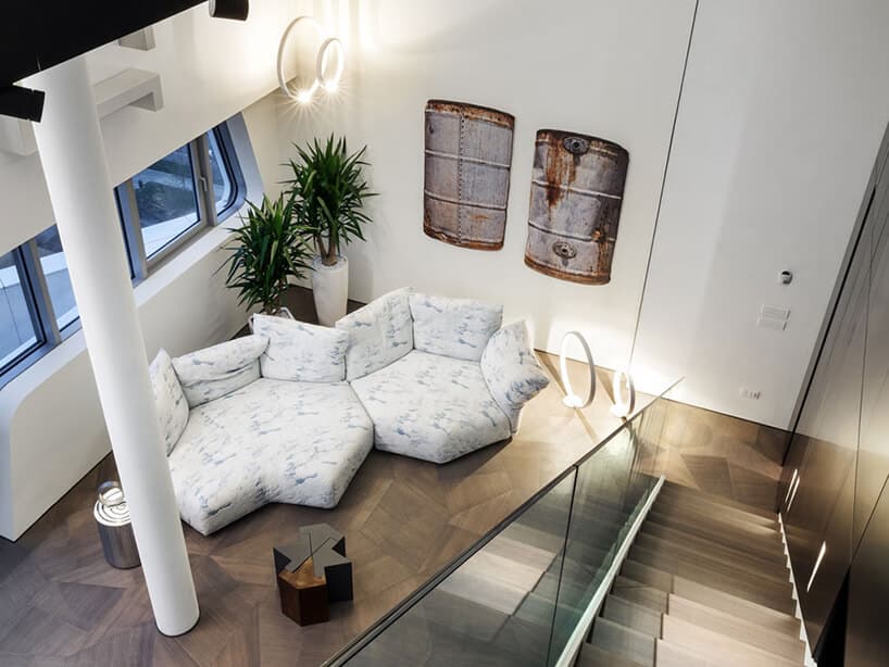 elegancki penthouse od Zaha Hadid widok z antresoli na wyjątkową biało niebieska sofą w geometrycznych figurach