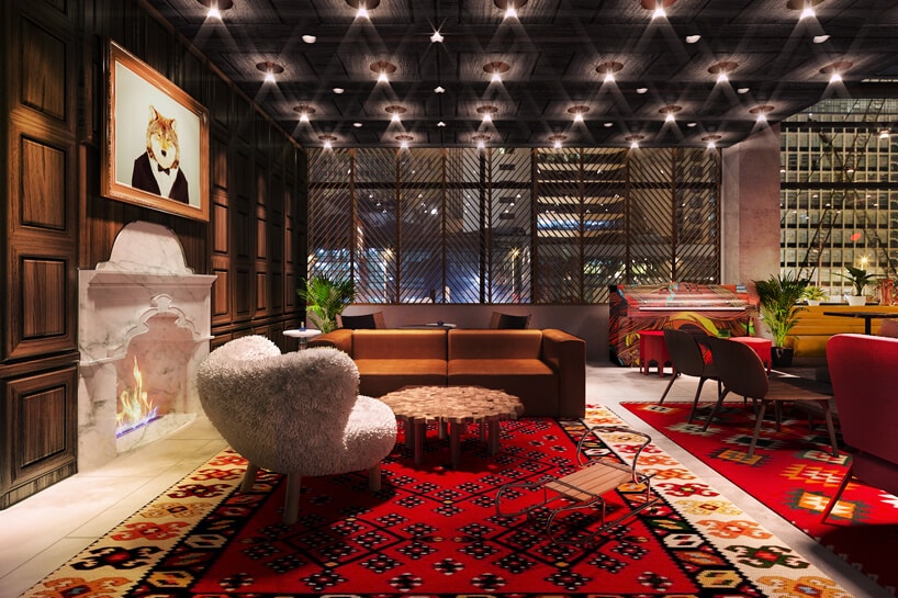 lobby hotelu ibis Styles Sarajewo z dużym dywanem, kominkiem i obrazem lisa w garniturze