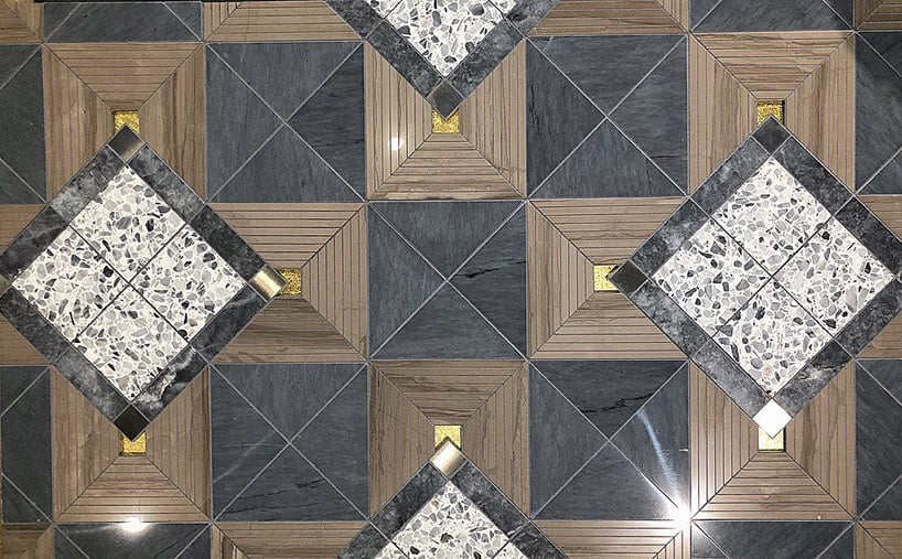 ciemne płytki we wzory geometryczne z mosiężnymi akcentami