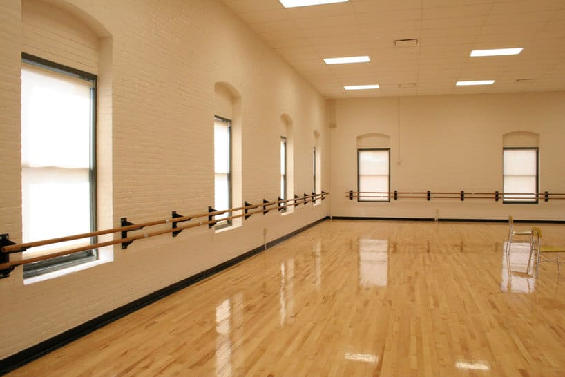 wypolerowana podłoga w sali tanecznej z oknami
