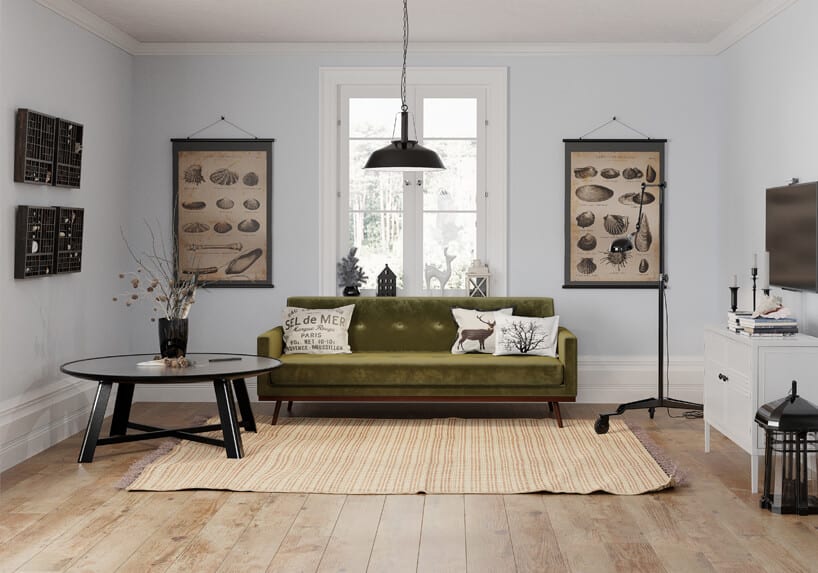 zielna sofa na drewnianych brązowych nogach w białym wnętrzu obok czarnego okrągłego niskiego stolika ze szklanym blatem