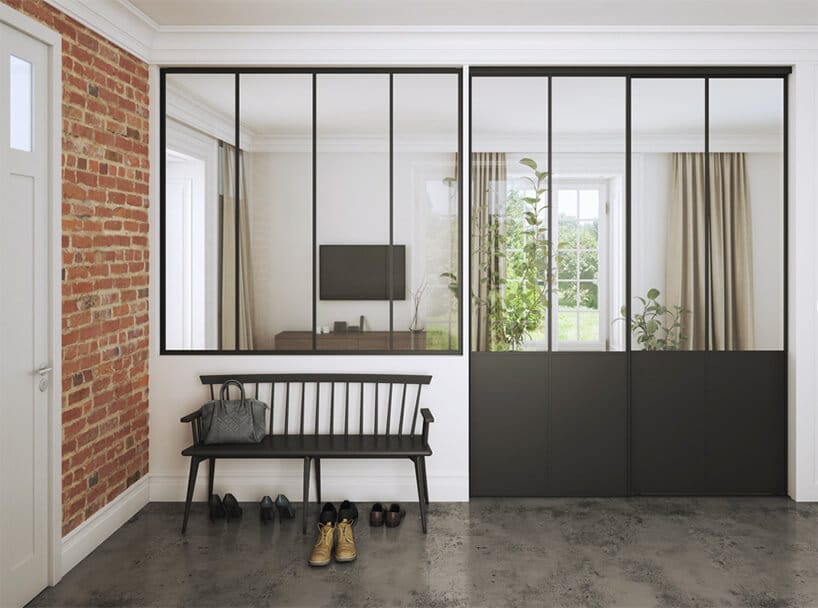 drewniana ławka przy białej i ceglanej ścianie przy otwieranych szklanych drzwiach z metalowymi wstawkami w kolorze szarym