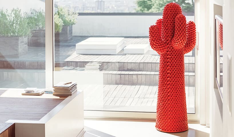 czerwony stojak Cactus od Gufram na tle drewnianego ciemnego tarasu