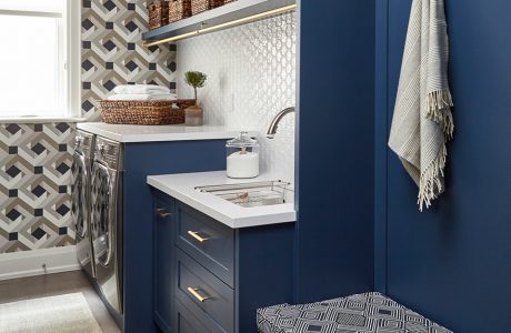 małe biało niebieskie pomieszczenie z dwoma srebrnymi urządzeniami do prania i suszenia
