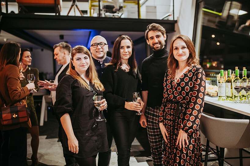 redakcja MAGAZIF na zdjęciu podczas prezentacji oferty w shoroomie Aqina obok białego stołu z szarym krzesłem