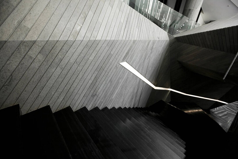 czarne stylowe schody obok szarej ściany z desek