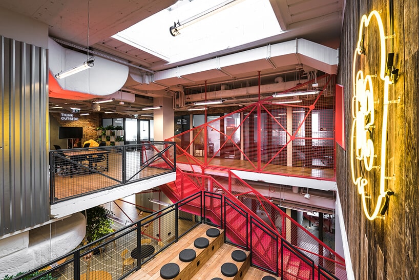 przestrzeń coworkingowa Brain Embassyduże żółte logo oraz czerwone metalowe schody