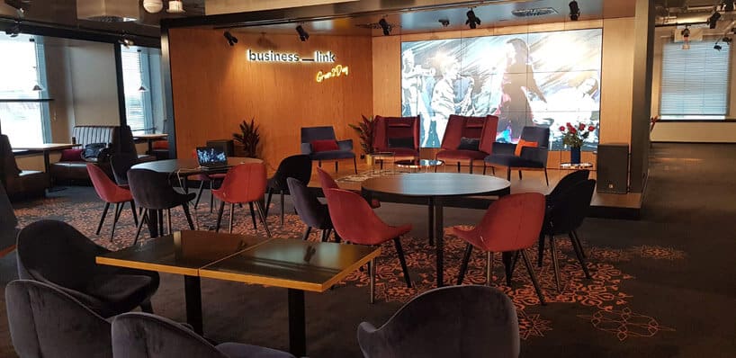 sala konferencyjna z pomarańczowymi i czarnymi krzesłami