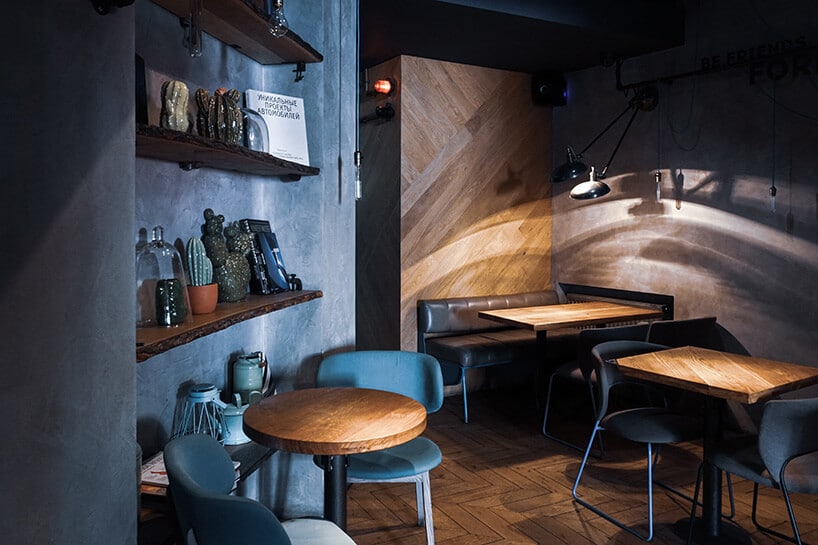wnętrze restauracji ze stolikami z drewna oraz krzesłami w kolorze niebieskim oraz czarnym skózanym