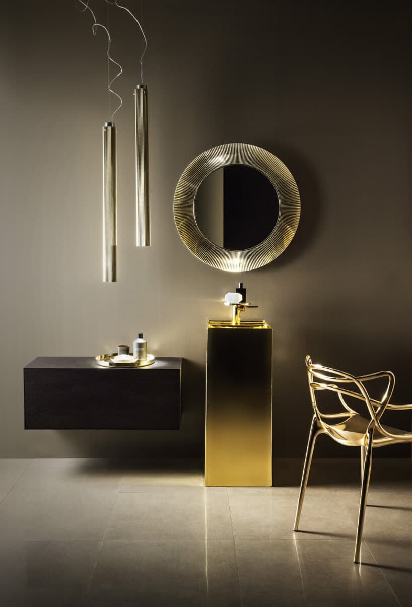 elegancka aranżacja łazienki ze złotą umywalką pod okrągłym lustrem z grubą ramą od Kartell by Laufen