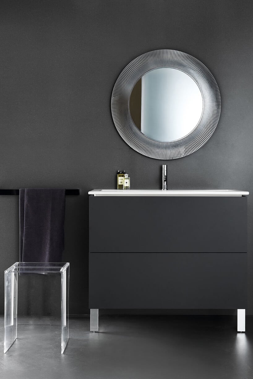 elegancka ciemna łazienka z przeźroczystym stołkiem i wiszącym nad czarną szafką lustrem z grubą transparentną ramą od Kartell by Laufen