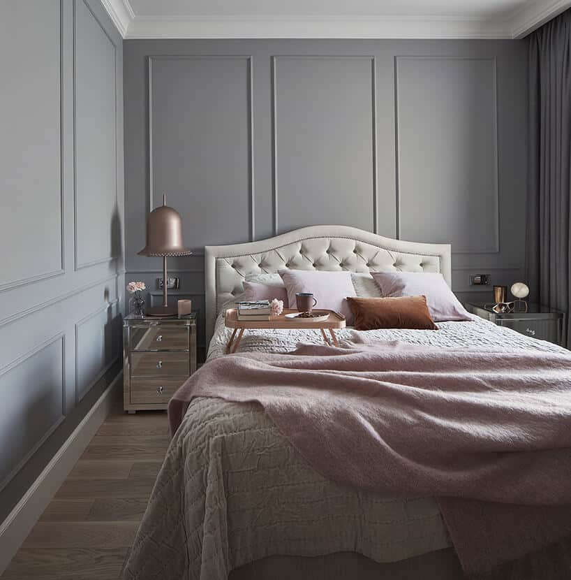 sypialnia z dużym beżowym łóżkiem z pikowanym zagłowiem oraz dodatkami w kolorze pudrowego różu
