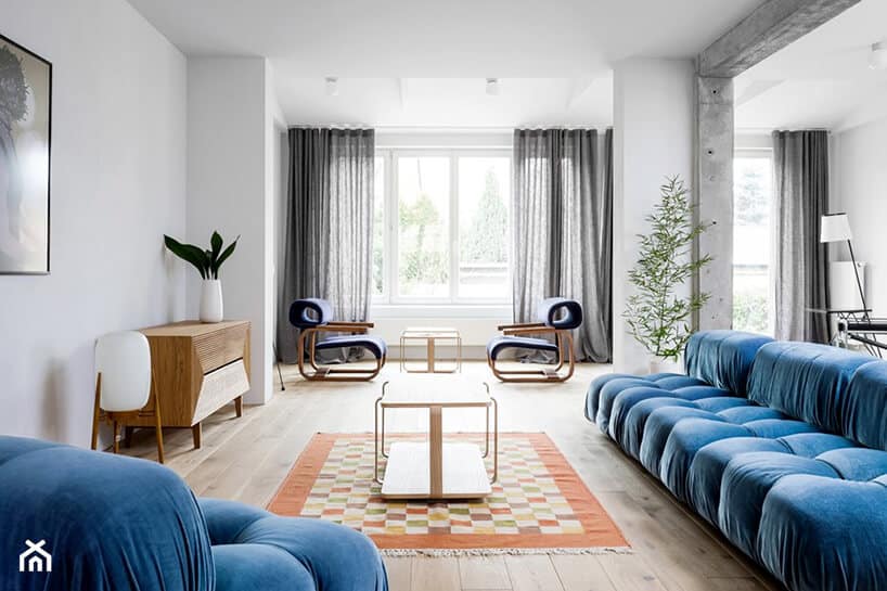 duża niebieska sofa z niebieskim fotelem w jasnym eleganckim salonie