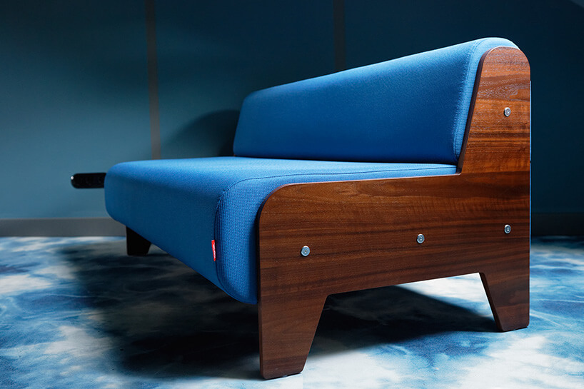 niebieska sofa z ciemno brązowym drewnianym stelarzem