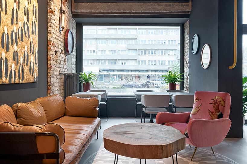 wnętrze restauracji POP in projektu Sikora Wnętrza duża brązowa sofa przy drewnianym stoliku z drewnianego plastra drzewa