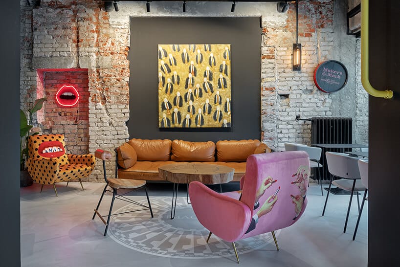 wnętrze restauracji POP in projektu Sikora Wnętrza różowy fotel na tle brązowej sofy i obrazu na szarej ścianie