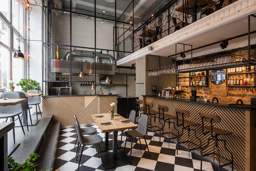 wnętrze restauracji z drewnianymi stolikami i metalowymi krzesłami