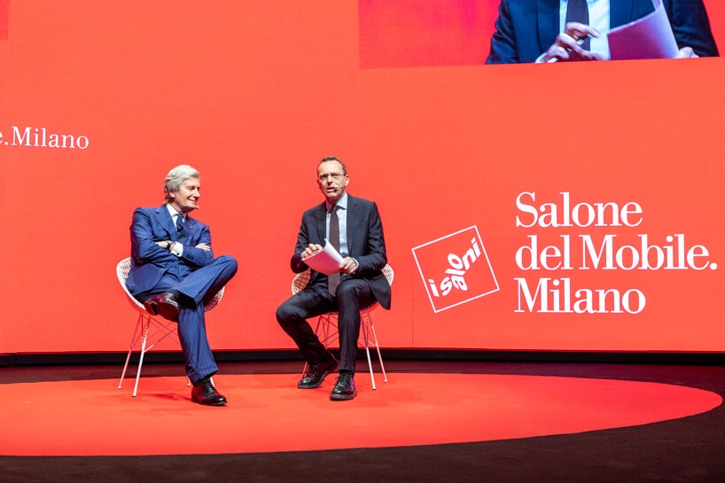 dwóch mężczyzn w garniturach siedzących scenie podczas Salone del Mobile 2019