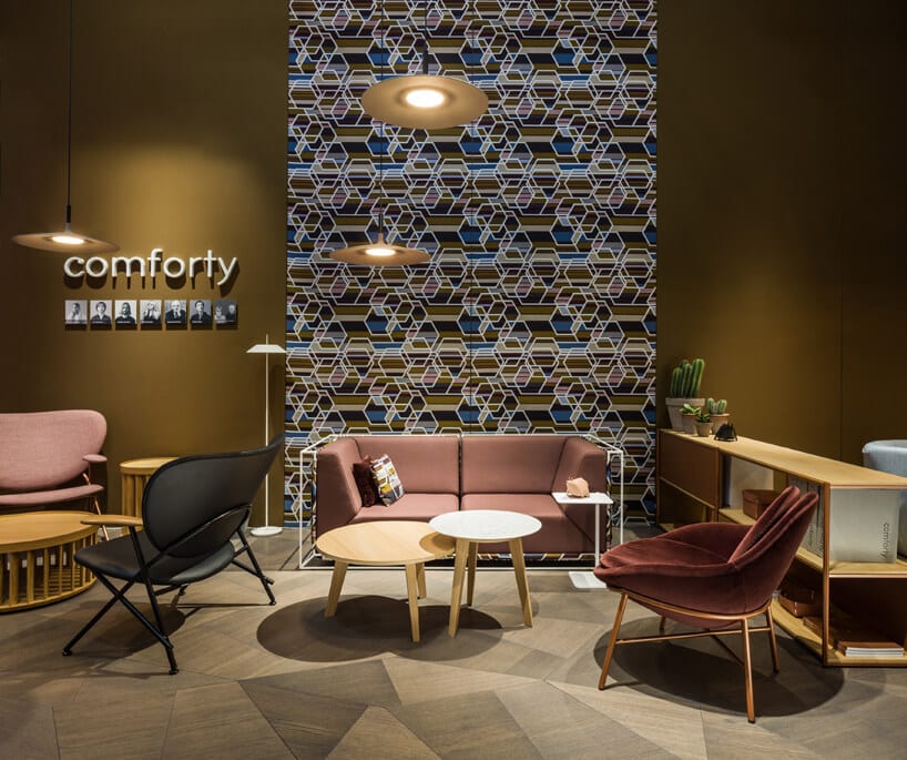 mała sofa za stolikiem pomiedzy różnymi krzesłami od comforty
