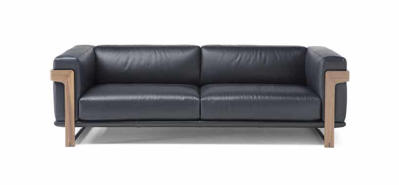 czarna sofa z drewnianymi dodatkami na białym tle