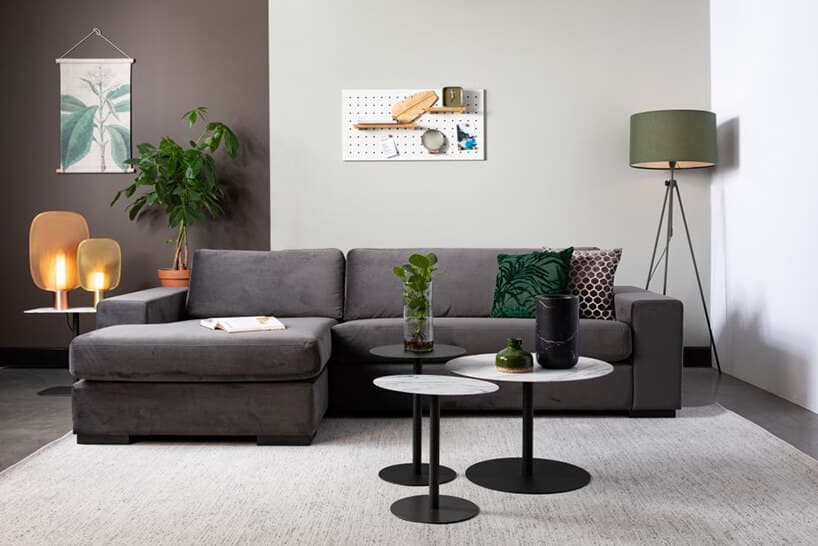 czarna sofa Fiep od Zuiver z częścią do spania przy trzech małych stolikach z czarnym i biało czarnym blatem
