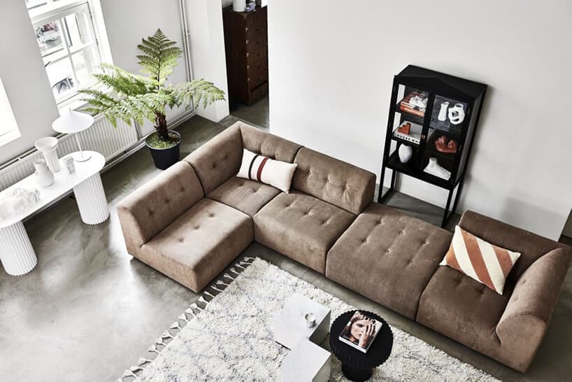 elegancka narożna brązowa sofa Vint od HK Living w jasnym salonie z ciemną podłogą przy jasnym dywanie