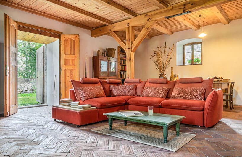 ceglana narożna sofa modułowa Gala Collezione w salonie z drewniany filarami