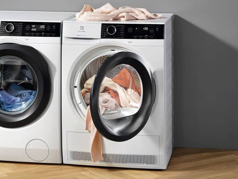 nowoczesna biała inteligetnea suszarka do ubrań marki Electrolux z otwartym drzwiczkami obok pralki marki Electrolux