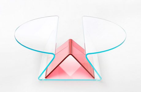 przeźroczysty stolik z powyginanego szkła z czerwonym akcentem