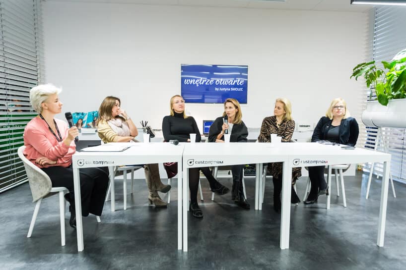 sześc kobiet siedzących przy 3 stołach