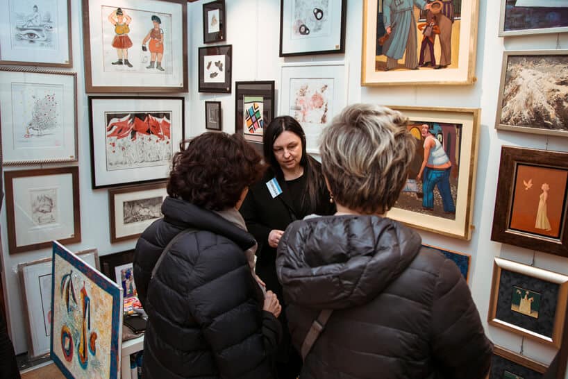 trzy kobiety na tle obrazów na Targach Sztuki Dostępnej 2019