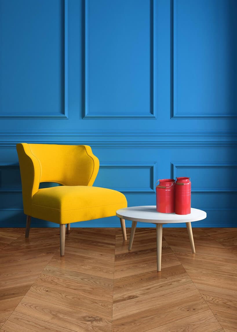 żółty fotel na drewnianej podłodze na tle niebieskiej ściany