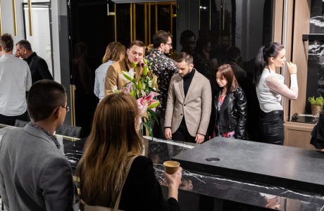 odwiedzający na stoisku Stoisko ernestrust podczas Warsaw Home 2019 dookoła czarnej wyspy z kamiennym blatem