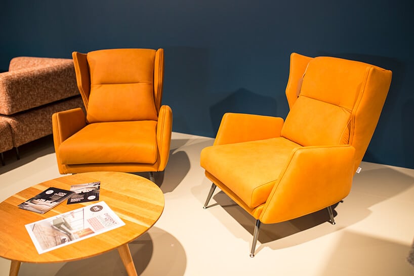 dwa pomarańczowe fotele na stoisku ARIS CONCEPT podczas Warsaw Home 2019 przy okrągłym drewnianym stoliku