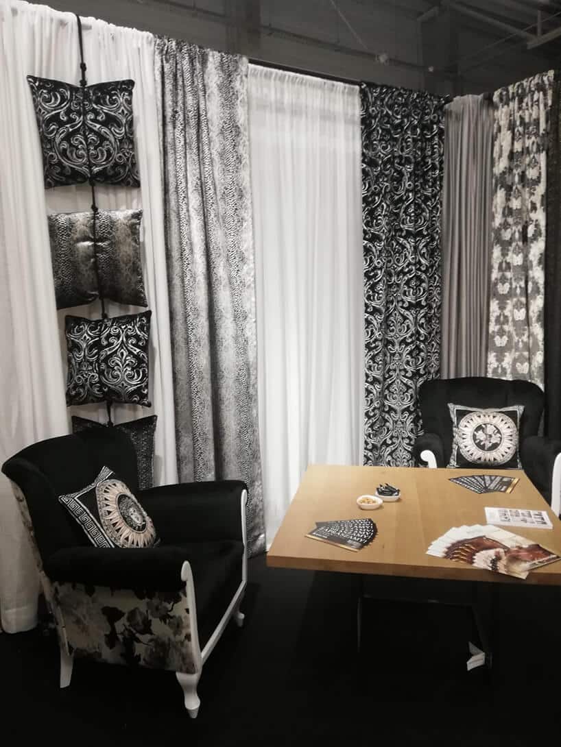 eleganckie stoisko RAD-POL podczas Warsaw Home 2019 dwa czarno białe fotele na tle eleganckich poduszek o raz firan i zasłon