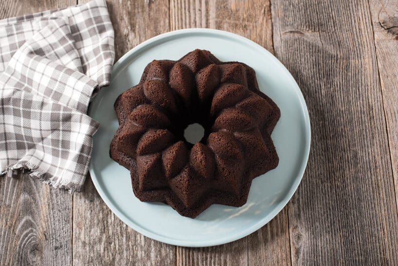 brązowa babka na białym talerzu obok ręcznika