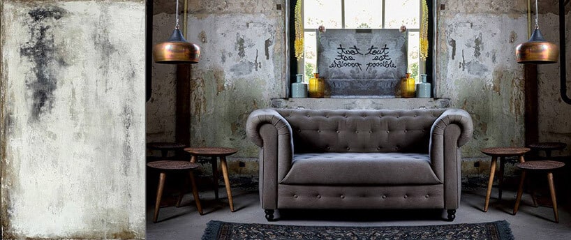 szara sofa we wnętrzu z odrapanymi ścianami