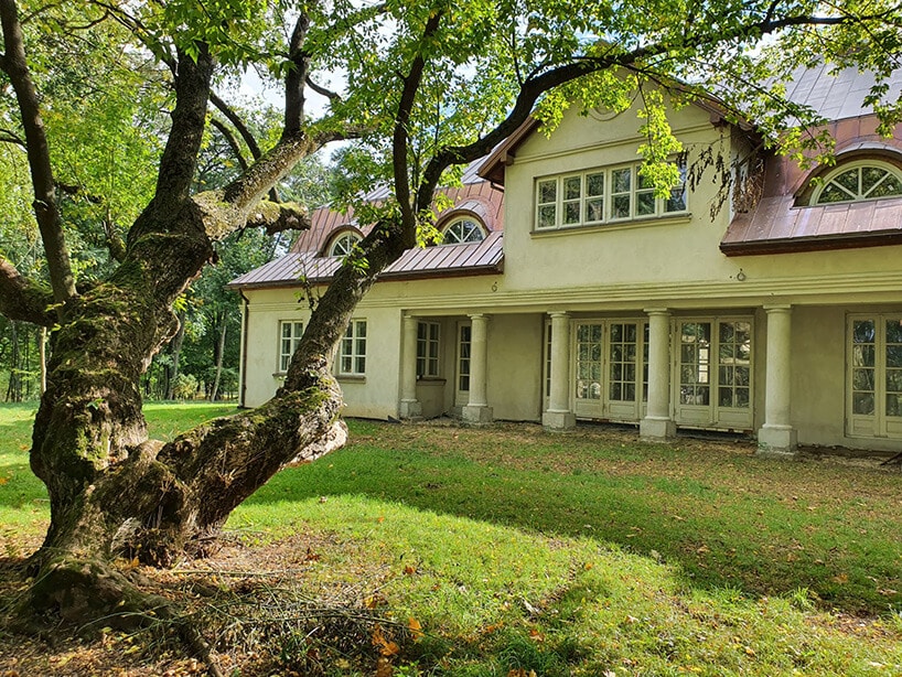 dworkowy pałac z czerwonym dachem przy starym drzewie