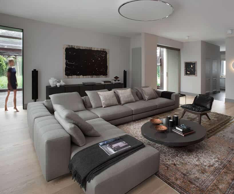 duży elegancki salon z dużą narożną szarą sofą