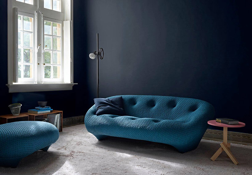 niebieska sofa na tle czarnej ściany