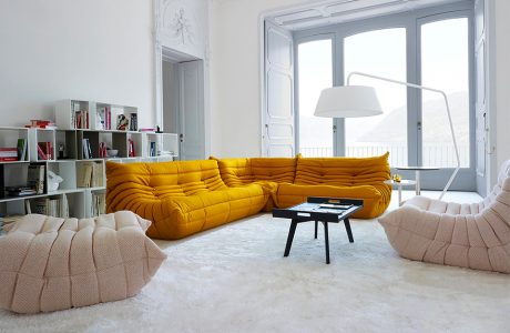 pomarańczowa sofa w białym wnętrzu