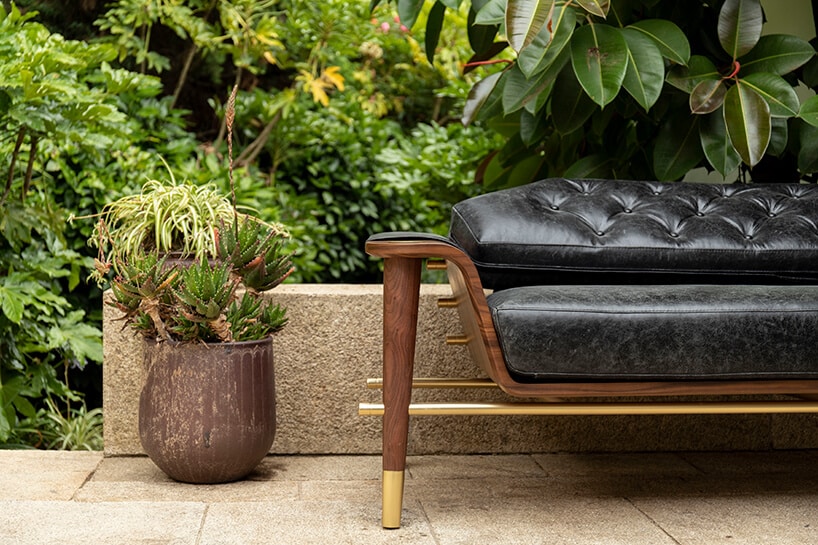 wnętrze wyjątkowego showroom covet valley elegancka sofa z czarnym siedziskiem drewnianym stelażu ze złotymi akcentami