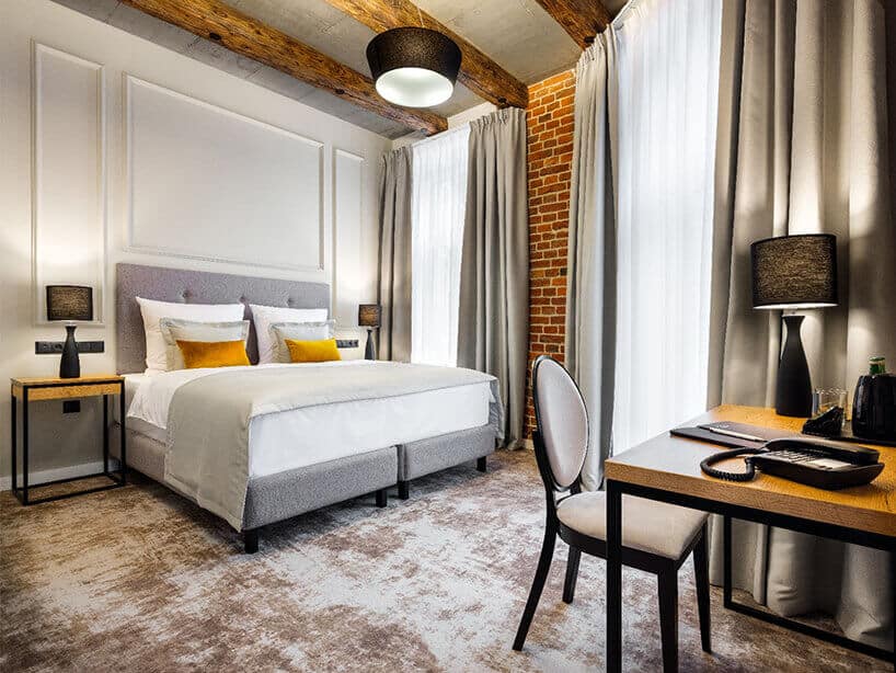 Wawel Queen pokój hotelowy z szarą wykładziną, łóżkiem oraz krzesłem stolikiem